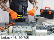 Electrician working on an electrical panel with wires. electrician at work. Стоковое фото, фотограф Сергей Чуйко / Фотобанк Лори