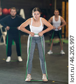 Determined young girl working out with resistance band in gym. Стоковое фото, фотограф Яков Филимонов / Фотобанк Лори