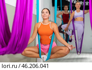 Girl doing Baddha Konasana asana in suspended hammock with hands in mudra. Стоковое фото, фотограф Яков Филимонов / Фотобанк Лори