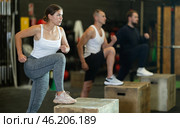 Sportive young girl doing step-up exercises with box during crossfit workout. Стоковое фото, фотограф Яков Филимонов / Фотобанк Лори