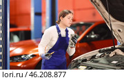 Female auto mechanic checking oil level in car engine in garage. Стоковое видео, видеограф Яков Филимонов / Фотобанк Лори