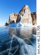 Baikal winter Lake on sunny February day. Famous Cape Sagan-Khushun or Three Brothers rocks are natural landmark of Olkhon Island and tourist destination. Blue clear ice with cracks around rocks. Стоковое фото, фотограф Виктория Катьянова / Фотобанк Лори