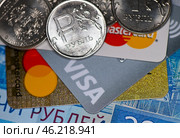 Кредитные карточки с логотипами MasterCard и Visa, рублевые монеты и купюры. Редакционное фото, фотограф E. O. / Фотобанк Лори