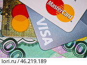 Кредитные карточки с логотипами MasterCard и Visa, рублевые купюры. Редакционное фото, фотограф E. O. / Фотобанк Лори