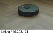 round robot vacuum moves methodically across the bathroom floor, its sensors scanning for dust and hair. Стоковое видео, видеограф Feruza Tashmetova / Фотобанк Лори