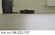 round robot vacuum moves methodically across the bathroom floor, its sensors scanning for dust and hair. Стоковое видео, видеограф Feruza Tashmetova / Фотобанк Лори