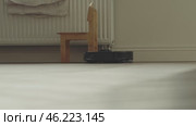 round robot vacuum moves methodically across the bathroom floor, its sensors scanning for dust and hair. Стоковое видео, видеограф Feruza Tashmetova / Фотобанк Лори
