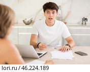 Young man listen attentively and intently to woman of seller, who tells about advantages of making microloan in credit institution. Стоковое фото, фотограф Яков Филимонов / Фотобанк Лори