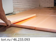 Worker lays polystyrene foam on the floor. Insulation of the house, installation of underfloor heating. Стоковое фото, фотограф Коханова Наталья / Фотобанк Лори
