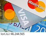 Кредитные карточки с логотипами MasterCard и Visa и рублевые купюры. Редакционное фото, фотограф E. O. / Фотобанк Лори