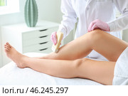 Beautician epilating legs of young woman in salon. Стоковое фото, фотограф Pixel_shot / Фотобанк Лори
