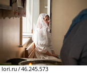 Gomel, Belarus - 02 Sept 2023: Portrait beautiful bride with veil sitting near windowsill in the church. Редакционное фото, фотограф Дмитрий Нечаев / Фотобанк Лори