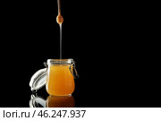 Jar and dipper with tasty honey on dark background. Стоковое фото, фотограф Pixel_shot / Фотобанк Лори