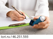 Doctor writing out prescription for using inhaler against asthma. Стоковое фото, фотограф Pixel_shot / Фотобанк Лори
