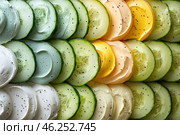 Thin slices of fresh cucumber, alternating with creamy spreads of various shades: white, light green, yellow and orange. The entire composition is carefully laid out in a symmetrical pattern. Each layer is sprinkled with small black seeds or spices, which adds contrast and textural variety. Visually, the image looks fresh, appetizing and aesthetically pleasing, emphasizing the natural colors and textures of the ingredients. Стоковое AI-изображение, AI-художник Анна Кривицкая / Фотобанк Лори