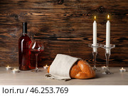 Traditional challah bread with wine and glowing candles on wooden background. Shabbat Shalom. Стоковое фото, фотограф Pixel_shot / Фотобанк Лори