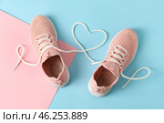 Pair of sportive shoes and heart made of laces on color background. Стоковое фото, фотограф Pixel_shot / Фотобанк Лори