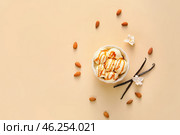 Ramekin with tasty vanilla ice cream and almond on color background. Стоковое фото, фотограф Pixel_shot / Фотобанк Лори