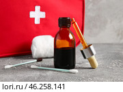 Bottle with iodine, pipette, cotton swabs and first aid kit on grunge background. Стоковое фото, фотограф Pixel_shot / Фотобанк Лори