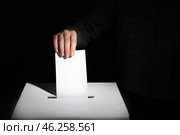 Voting woman near ballot box on dark background. Стоковое фото, фотограф Pixel_shot / Фотобанк Лори