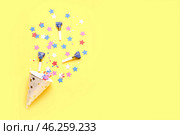 Composition with party hat and whistles on pale yellow background. Стоковое фото, фотограф Pixel_shot / Фотобанк Лори