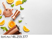 Copper strainer, double jigger, cobbler shaker and cocktail ingredients on grey background. Стоковое фото, фотограф Pixel_shot / Фотобанк Лори