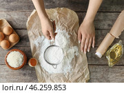Woman sifting rice flour at table, top view. Стоковое фото, фотограф Pixel_shot / Фотобанк Лори