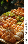 Golden tray overflowing with delicious baklava, turkish delights and other middle eastern sweets. Стоковое AI-изображение, AI-художник Юрий Поздников / Фотобанк Лори