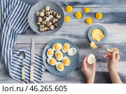 Woman preparing tasty deviled eggs on wooden table. Стоковое фото, фотограф Pixel_shot / Фотобанк Лори