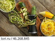 Fresh zucchini spaghetti with spiral grater on wooden table. Стоковое фото, фотограф Pixel_shot / Фотобанк Лори