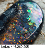 Macro photo of a gemstone, probably opal, with vibrant shades of green, blue, purple and orange. The stone looks like a piece of space, reflecting different colors and light reflections. The structure of the stone is a beautiful network of fractures and cracks, which give it a mysterious and mystical look. Light falling on the stone emphasizes its internal texture and play of colors, creating the effect of a magical glow. Стоковое AI-изображение, AI-художник Анна Кривицкая / Фотобанк Лори