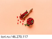 Wooden spoon and bowl with lingonberries on beige background. Стоковое фото, фотограф Pixel_shot / Фотобанк Лори