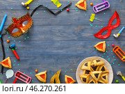 Frame made of party decor and Hamantaschen cookies with rattles for Purim holiday on color wooden background. Стоковое фото, фотограф Pixel_shot / Фотобанк Лори