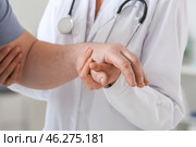 Female doctor with senior man suffering from Parkinson syndrome in clinic. Стоковое фото, фотограф Pixel_shot / Фотобанк Лори