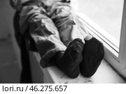 Legs of homeless little girl sitting on window sill. Стоковое фото, фотограф Pixel_shot / Фотобанк Лори