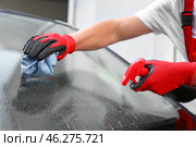 Male worker cleaning car window after applying tinting foil outdoors. Стоковое фото, фотограф Pixel_shot / Фотобанк Лори