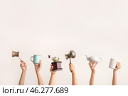 Female hands with coffee grinder, jezve, teapot and cups on light background. Стоковое фото, фотограф Pixel_shot / Фотобанк Лори