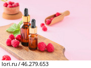 Bottles of raspberry essential oil on color background. Стоковое фото, фотограф Pixel_shot / Фотобанк Лори