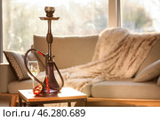 Hookah, pomegranate and glass of alcohol on table in room. Стоковое фото, фотограф Pixel_shot / Фотобанк Лори