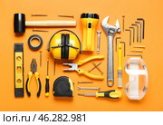 Hearing protectors with builder's tools on color background. Стоковое фото, фотограф Pixel_shot / Фотобанк Лори