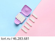 Tampons storage box and tampons on pink and blue background, top view. Стоковое фото, фотограф Pixel_shot / Фотобанк Лори