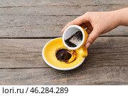 Woman reading coffee grounds at wooden table. Стоковое фото, фотограф Pixel_shot / Фотобанк Лори