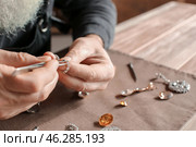 Jeweller examining adornment in workshop, closeup. Стоковое фото, фотограф Pixel_shot / Фотобанк Лори