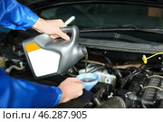 Male mechanic refilling car oil in service center. Стоковое фото, фотограф Pixel_shot / Фотобанк Лори