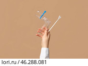 Doctor's hand with pap test tools on beige background. Стоковое фото, фотограф Pixel_shot / Фотобанк Лори