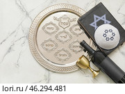 Passover Seder plate with wine, Jewish cap and Torah on white background. Стоковое фото, фотограф Pixel_shot / Фотобанк Лори