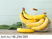 Basket with tasty bananas on wooden background. Стоковое фото, фотограф Pixel_shot / Фотобанк Лори