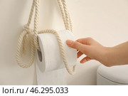 Young woman taking soft toilet paper in restroom. Стоковое фото, фотограф Pixel_shot / Фотобанк Лори