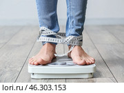 Young woman with anorexia measuring her weight at home. Стоковое фото, фотограф Pixel_shot / Фотобанк Лори
