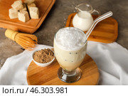 Board with glass of iced hojicha latte, chasen and powder on table. Стоковое фото, фотограф Pixel_shot / Фотобанк Лори